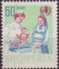 Colnect-1408-275-Albanian-mother-and-nurse-weighing-infant.jpg