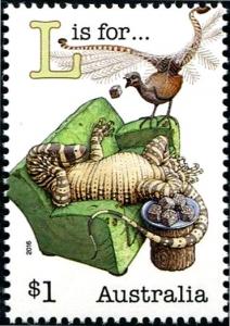 Colnect-4395-703-L-is-for-Lyrebird-on-lounge-Lace-monitor-Lamingtons-on-log.jpg