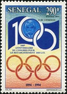 Colnect-2189-096-Coubertin-within-Anniversary-Emblem-and-Olympic-Rings.jpg