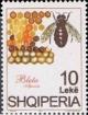 Colnect-1505-115-Honey-Bee-Apis-mellifica-next-to-Honeycomb.jpg