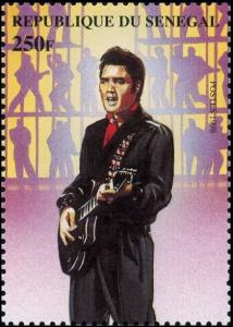 Colnect-2229-858-Elvis-with-Dark-Suit-and-Guitar-against-Shadow-Figures.jpg