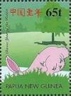 Colnect-2220-923-Pink-rabbit-hiding-behind-grass-knoll.jpg