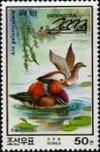 Colnect-2285-573-Mandarin-Duck-Aix-galericulata-Couple-in-Row-Boat.jpg